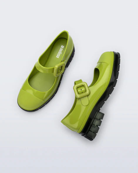 This Mary Jane by Melissa  features a bright green hue, slight heel, fun bubblegum scent, and large buckle detail top side pair