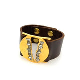 V cut-out round disc bracelet features 18K gold finish with black diamond baguette crystal accents. The genuine Italian leather band has an adjustable snap closure. Handcrafted in New York.