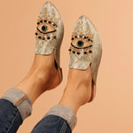 neutral colored slide mule with eye beaded embroidery detail on model