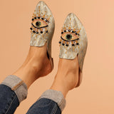 neutral colored slide mule with eye beaded embroidery detail on model
