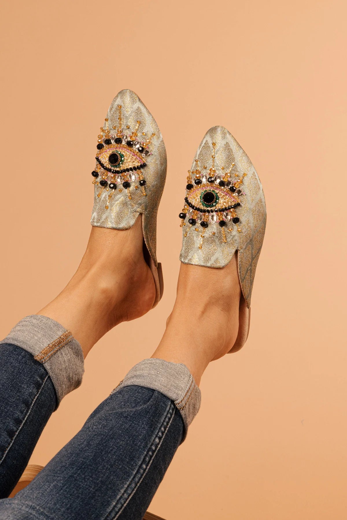 neutral colored slide mule with eye beaded embroidery detail on model