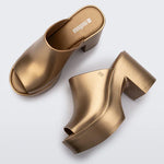 gold colored bubblegum scented heeled mule slip on sandal pair birds eye view