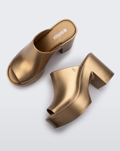 gold colored bubblegum scented heeled mule slip on sandal pair birds eye view