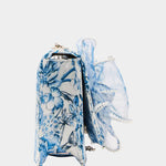 blue and white floral print hand bag with oversized bow that has pearl like detail side view
