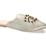 neutral colored slide mule with eye beaded embroidery detail side angle