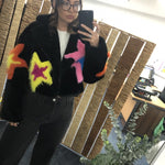 Black fur like jacket with colorful star designs on a model