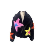 Black fur like jacket with colorful star designs on a white background