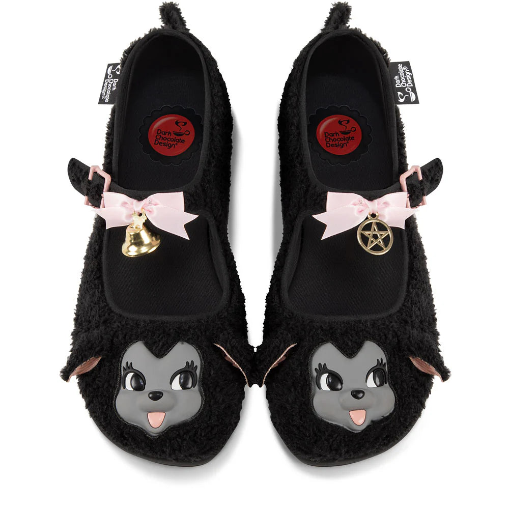 Black furry mary janes with cartoon lamb faces and decorative bow, bell, and pentagram elements on a white background