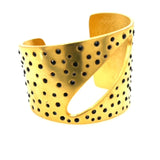 crystal studded metal cutout cuff bracelet features 18K gold finish with black diamond crystal studs. Handcrafted in New York.