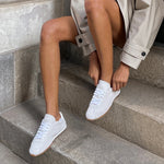 Italian-made sneaker featuring a trendy silhouette in ultra-soft suede. The SERINA sneaker in ivory features a rubber sole and white shoe laces on model.