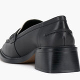 Black and cream colored leather loafer with heel back side view.