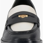 Black and cream colored leather loafer with heel front view.