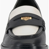 Black and cream colored leather loafer with heel front view.