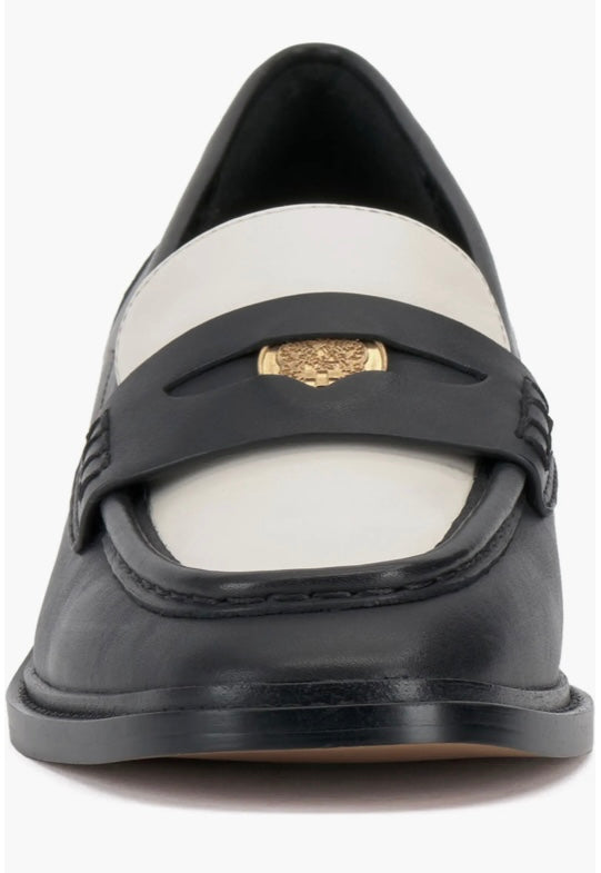 Black and cream colored leather loafer with heel front view.
