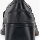 Black and cream colored leather loafer with heel back view.