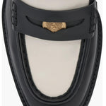 Black and cream colored leather loafer with heel top front view.
