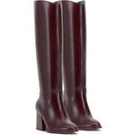 Brown knee-high tall shaft boot with soft round toe and a stacked block heel. Has zippered side closure and elastic inserts on the shaft for improved fit. The boot is lined with fabric and finished on the exterior with a leather-covered welt and rubber outsole pair