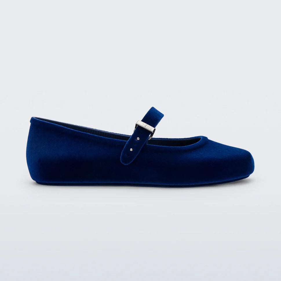 Melissa Soft Ballerina Velvet flat in deep blue. This classic women's ballet flat features a flocked finish, mimicking velvet, a fun bubblegum scent, adjustable buckle strap, an rounded toe side profile.