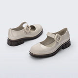The June Mary Jane by Melissa features a neutral beige hue, slight heel, fun bubblegum scent, and large buckle detail front back side profile