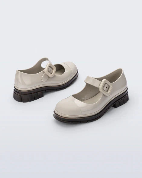 The June Mary Jane by Melissa features a neutral beige hue, slight heel, fun bubblegum scent, and large buckle detail front back side profile