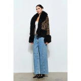 Woman wearing a leopard print coat with black faux fur trim on a white background showing full body to show length of jacket