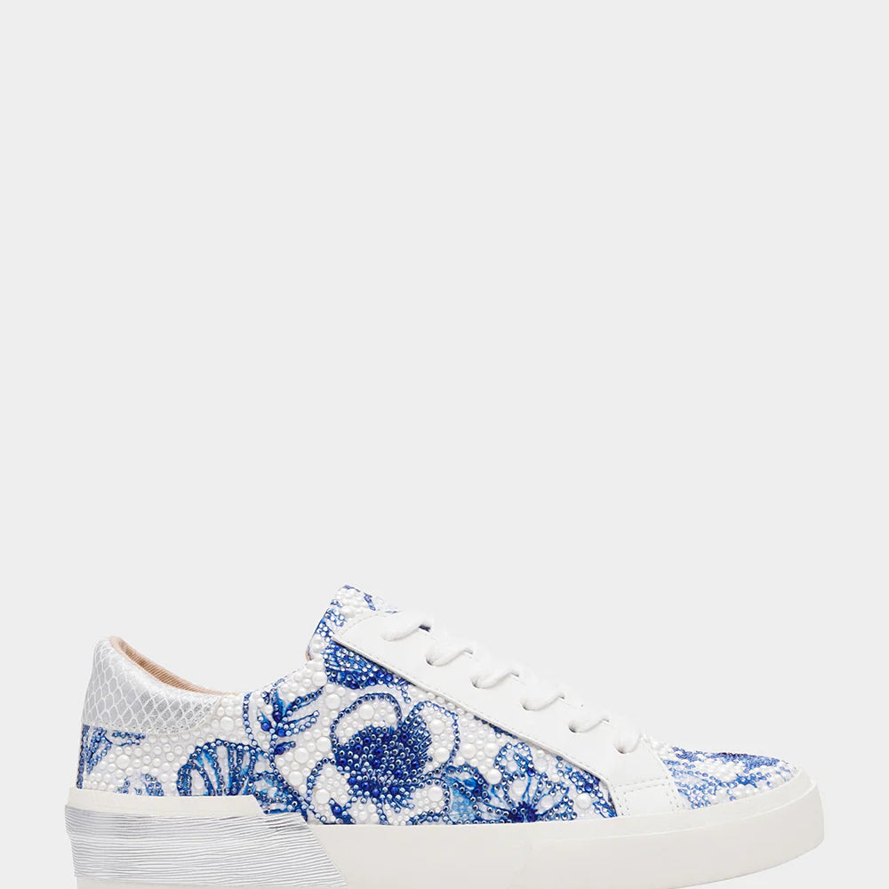 White sneakers with blue floral pattern on a white background
