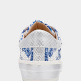 White sneaker with blue floral pattern on a white background