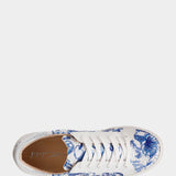 White sneaker with blue floral pattern on a white background