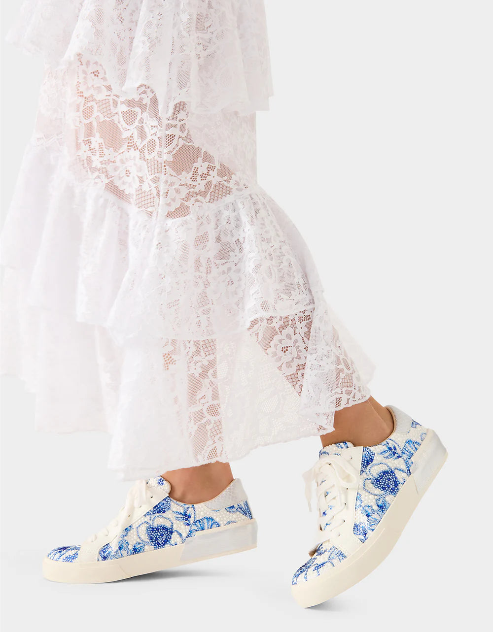 White lace dress with blue floral sneakers on a white background