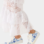 White lace dress with blue floral sneakers on a white background