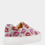 Decorative sneaker with pink and silver embellishments on a white background