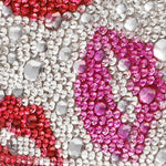 Close-up of a phone case with pink, red, and clear rhinestones.