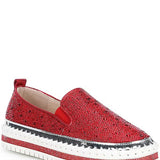 Red bejeweled slip-on shoe with a white sole close-up