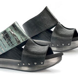 Black wedge sandals with black and alligator-like leather close-up