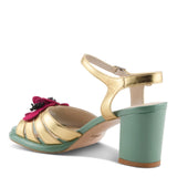 Open toe heeled shoe with gold strap, green sole, tan toe strap and raspberry flower inner side view