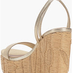 Beige wedge sandal with gold metallic straps and buckle closure rear view