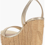 Beige wedge sandal with gold metallic straps and buckle closure rear view