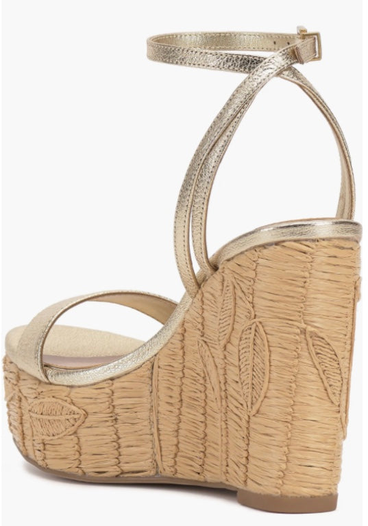 Beige wedge sandal with gold metallic straps and buckle closure rear view