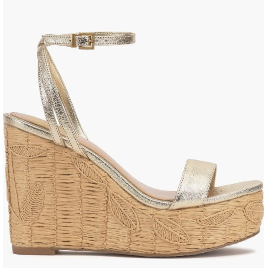 Beige wedge sandal with gold metallic straps and buckle closure tight view