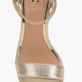 Beige wedge sandal with gold metallic straps and buckle closure overhead