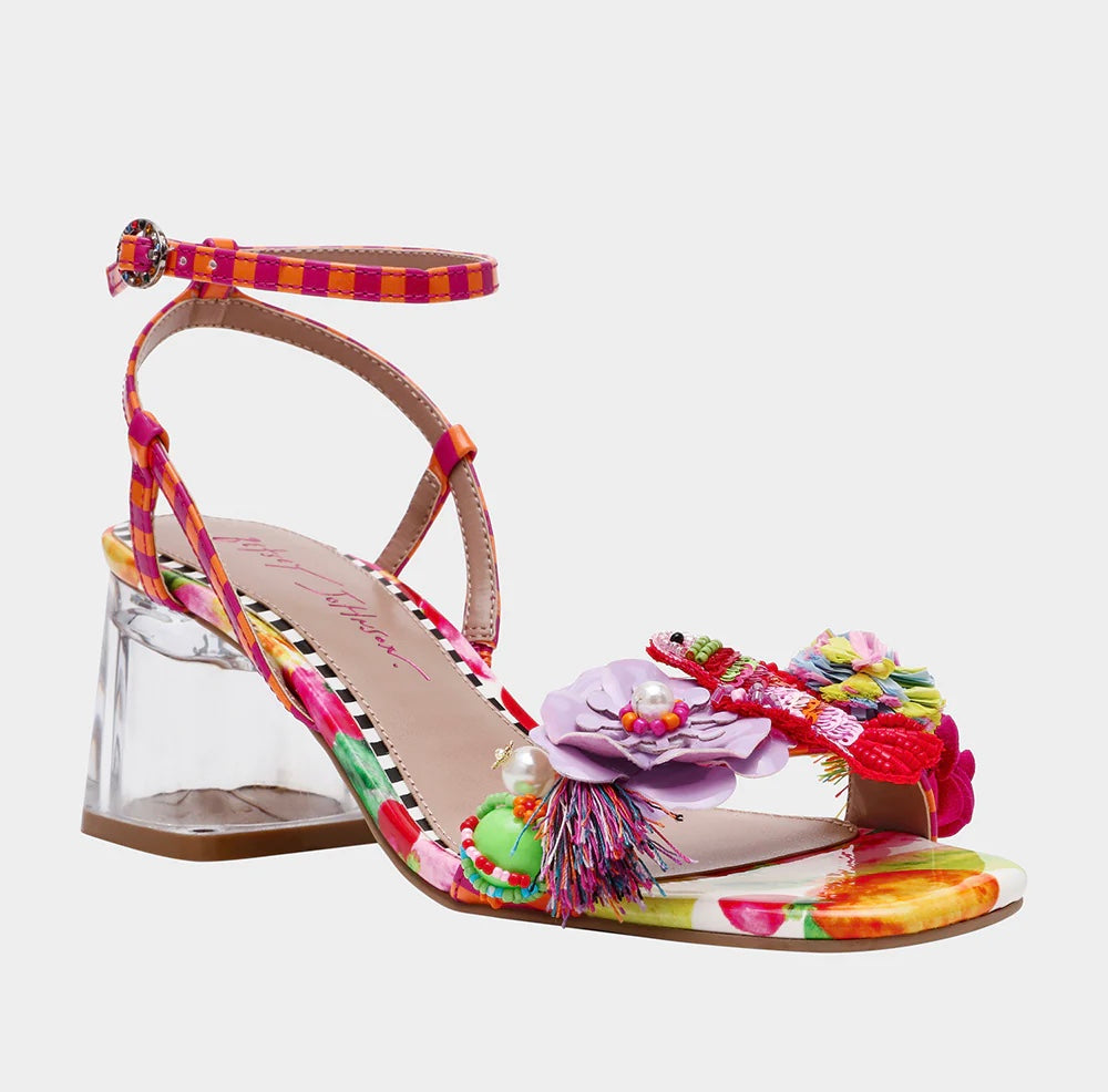 Colorful sandal with floral design, ankle strap, floral applique, and a clear heel from side