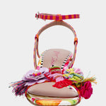 Colorful sandal with floral design, ankle strap, floral applique, and a clear heel from front
