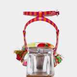 Colorful sandal with floral design, ankle strap, floral applique, and a clear heel from back