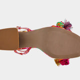 Colorful sandal with floral design, ankle strap, floral applique, and a clear heel from bottom
