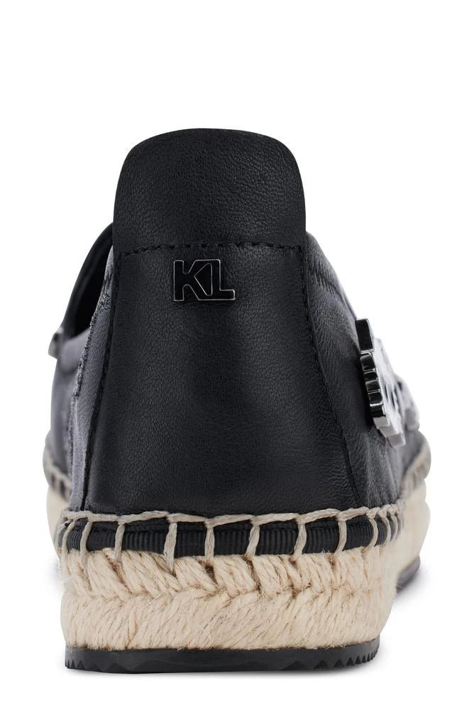 Black flat moccasin-styled shoe with decorative elements heel