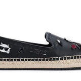 Black flat moccasin-styled shoe with decorative elements 