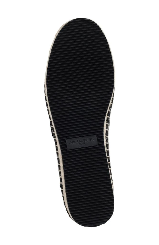 Black flat moccasin-styled shoe with decorative elements sole