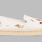 White flat moccasin-styled shoe with decorative elements 