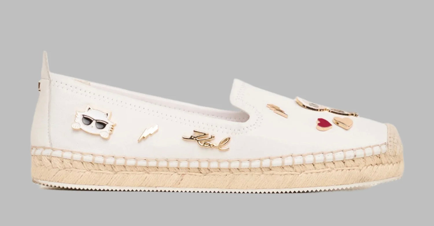 White flat moccasin-styled shoe with decorative elements 