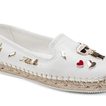 White flat moccasin-styled shoe with decorative elements side